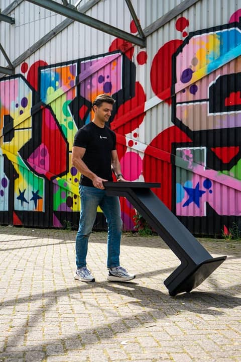 Mitarbeiter bewegt einen Onesix Kiosk mühelos vor einer Graffitiwand